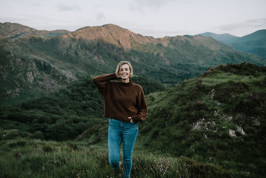 A woman standing on a mountain at sunset in Snowdonia, Wales